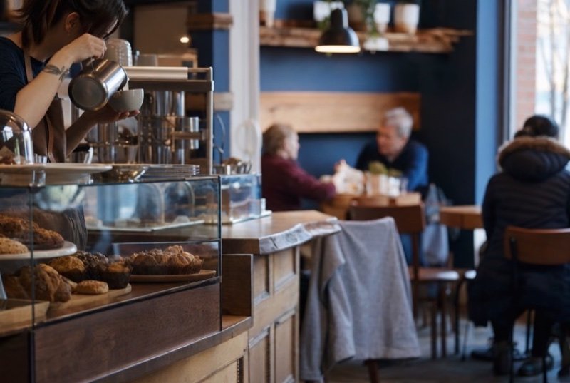 Café counter with pastries under glass as a barista pours coffee, the kind of bakery stop Glendale diners look up